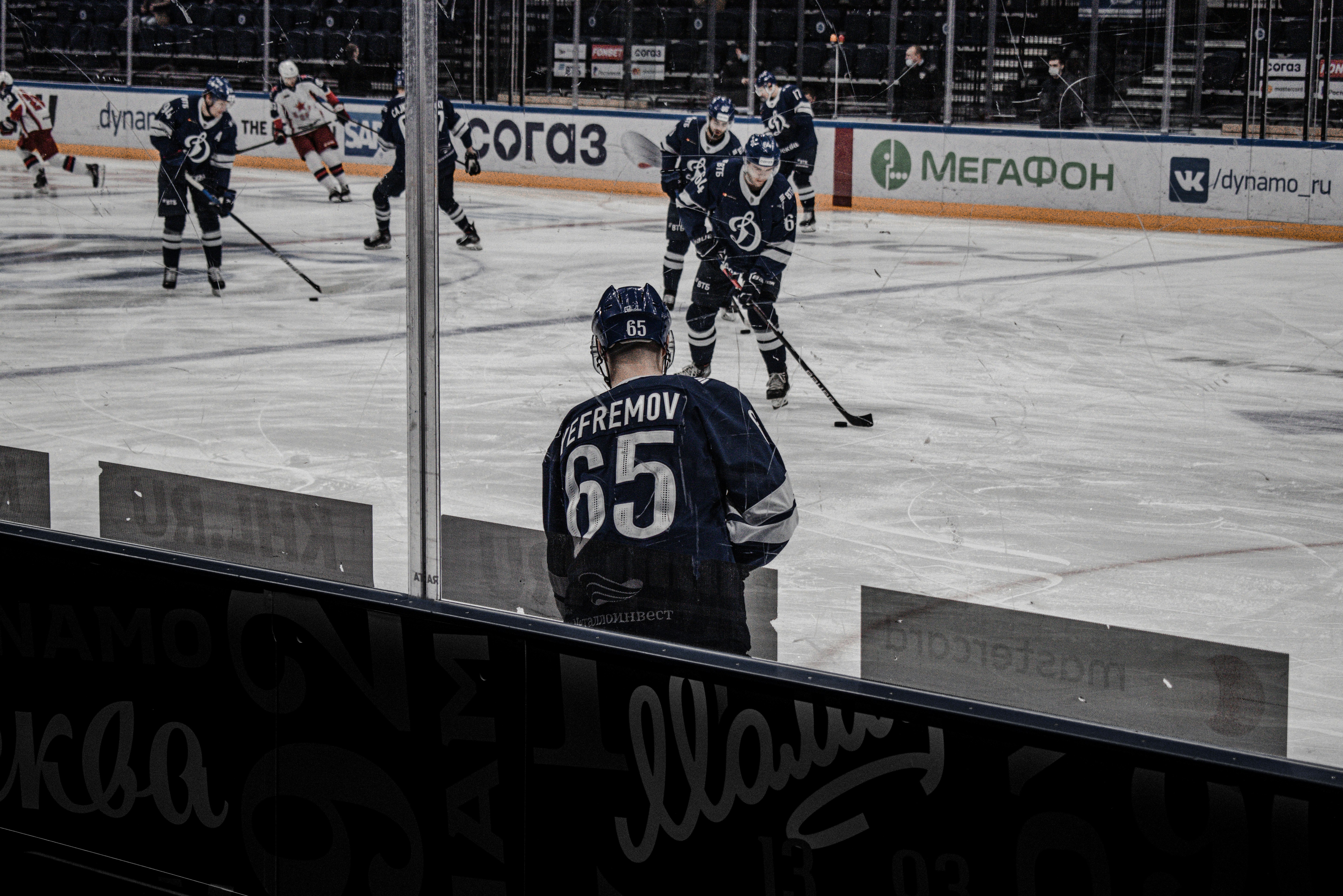 man in black ice hockey jersey holding hockey stick